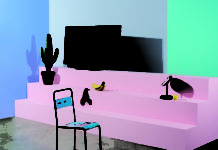 Loewe lanciert vierten OLED-Fernseher Fernseher von Loewe mit einem Designstuhl im Vordergrund