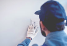 Alltron hat Wandtaster mit Schweizer Design im Sortiment Ein Monteur installiert einen Taster an der Wand.